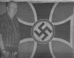 Ross Neale displays a German flag that was liberated from Rommel's headquarters in Normandy in 1944.